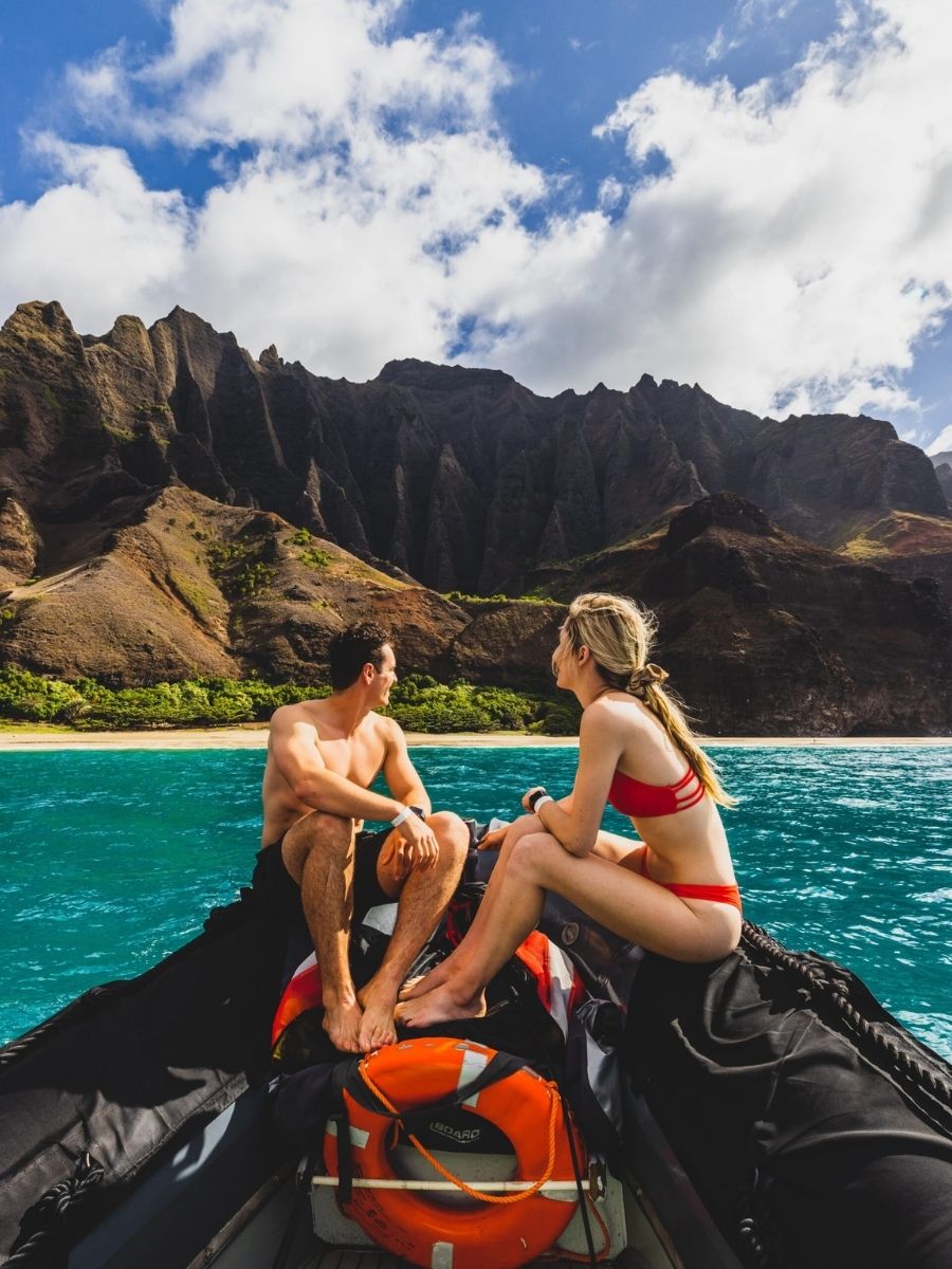 Adventure couple traveling to the napali coast on kauai via boat
