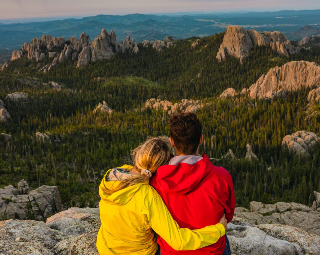 Adventure couple watching the sunrise at Black Elk Peak