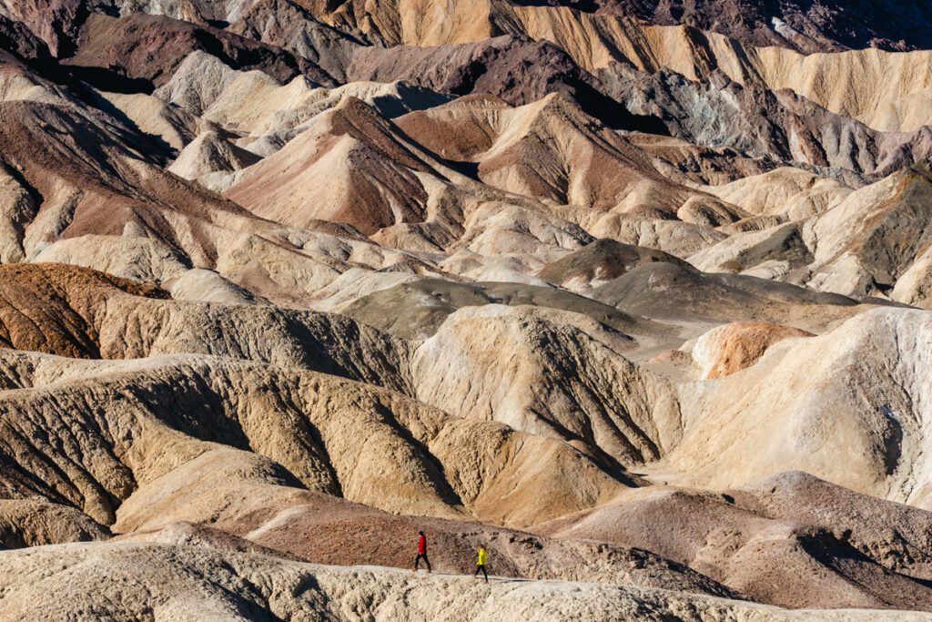 adventure couple hiking across 22 Mule Drive badlands