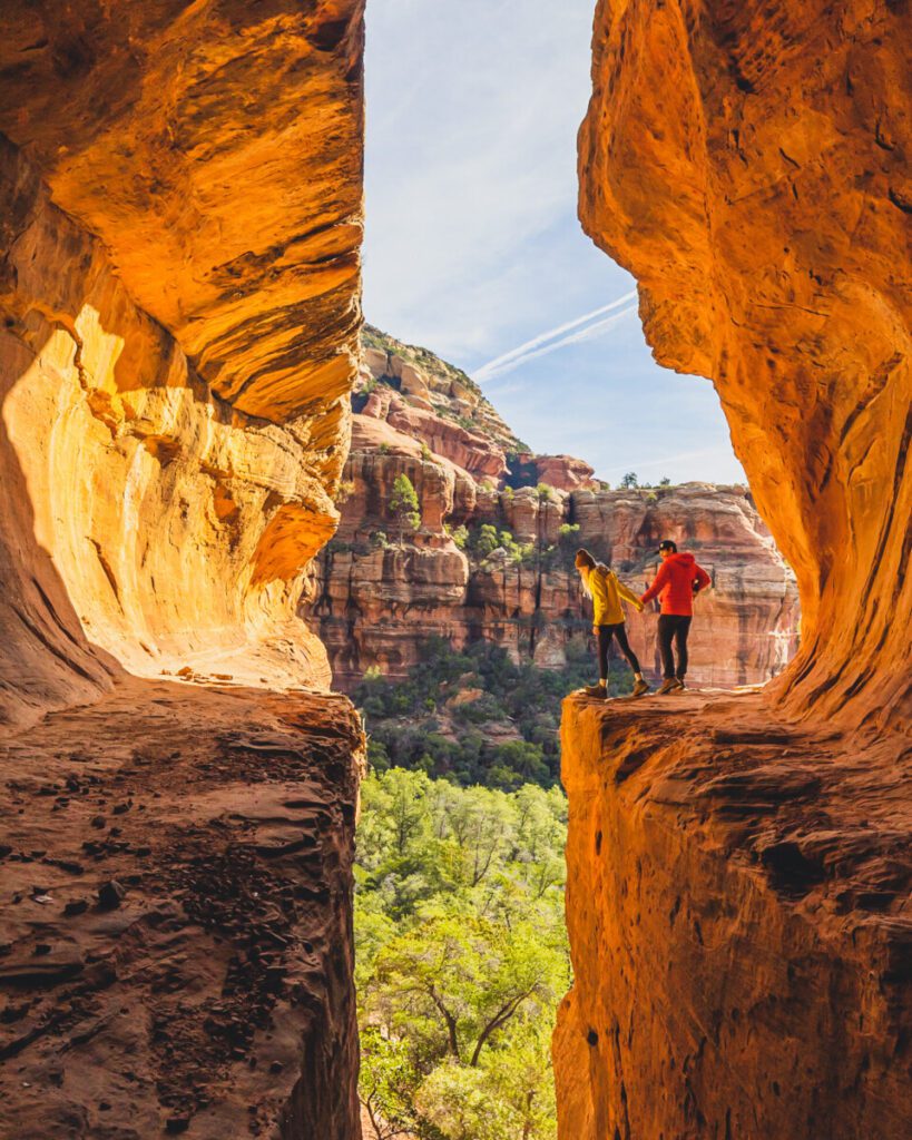 Adventure couple overlooking cliff at the Subway in Boynton Canyon Hike Sedona Arizona