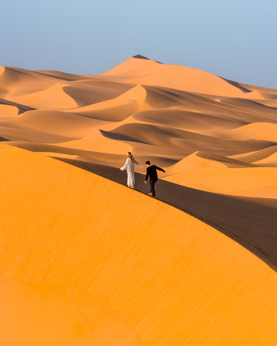 Couple walking on Abu Dhabi Sand Dunes at Telal Resort in Al Ain