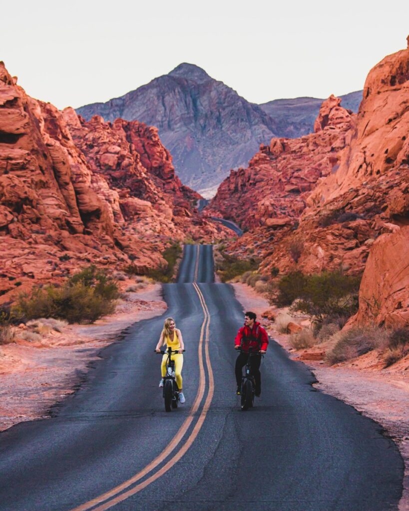 Adventure couple riding bikes down Fire Road in Valley of Fire State Park, 50 minutes from Las Vegas