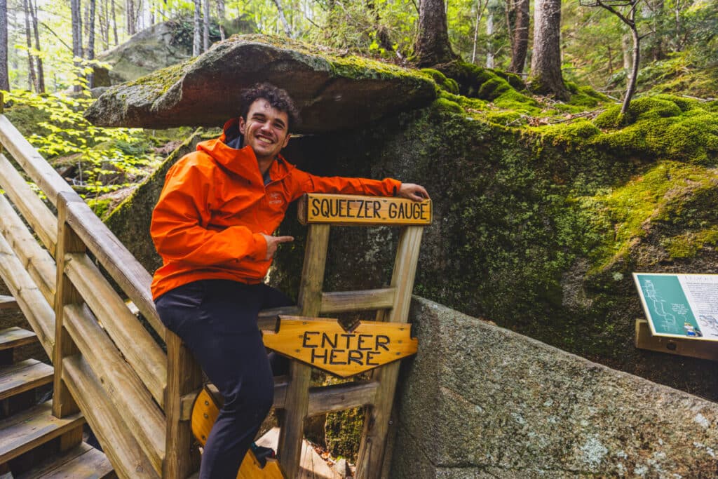 Stephen posing with the Squeezer Gauge, a cave inside of Lost River Gorge in New Hampshire