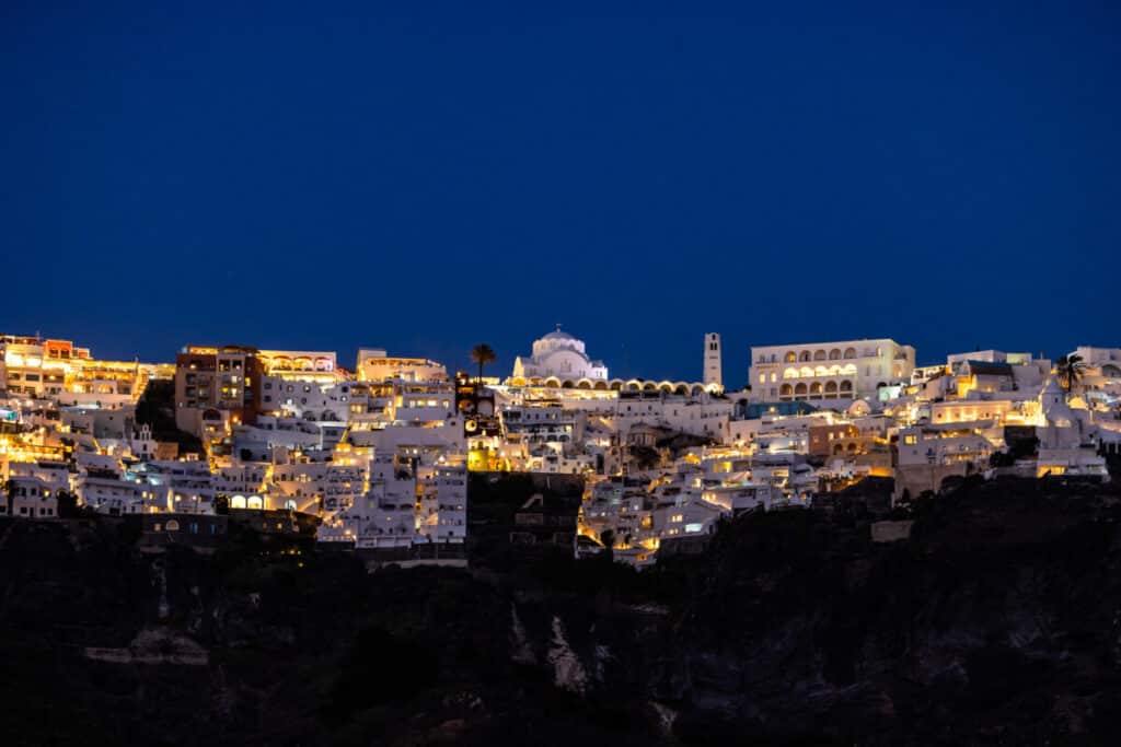 view of Fira Village in Santorini at night from a cruise ship