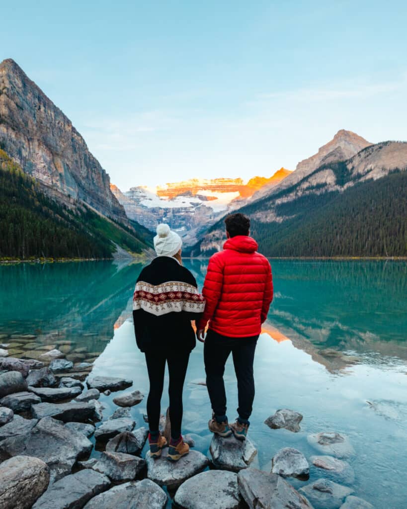 adventure couple overlooking Lake Louise at Sunrise in Banff National Park