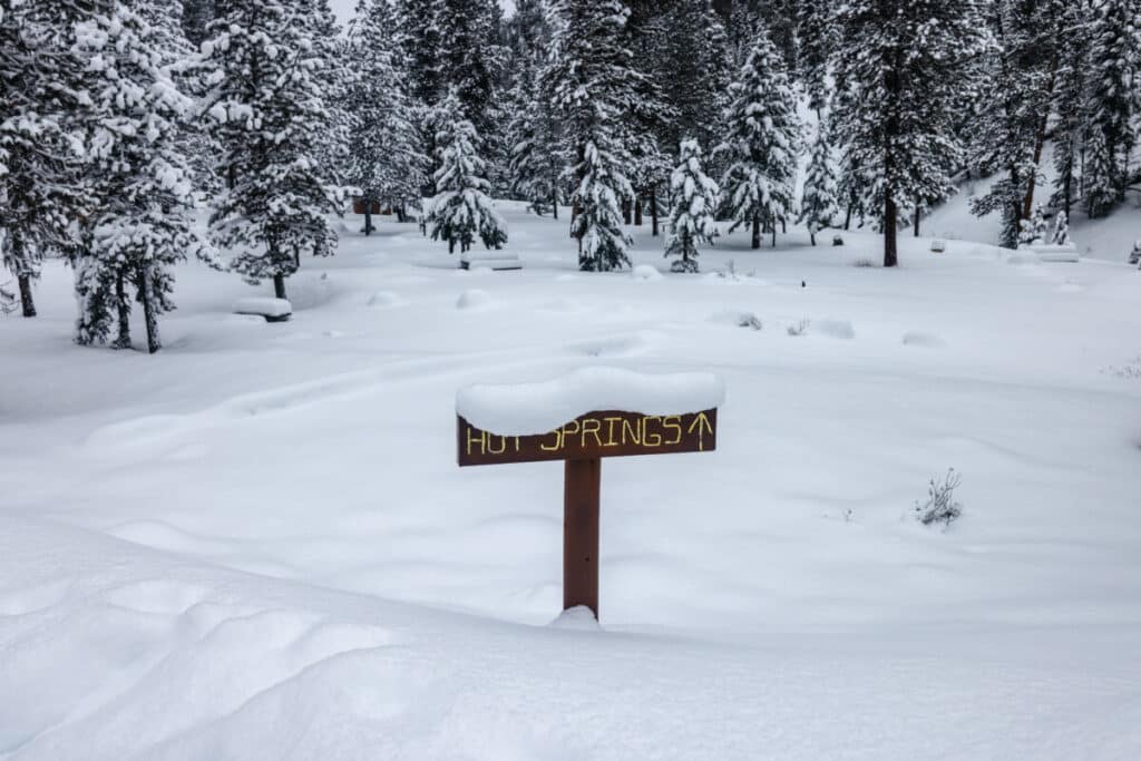 Sign for hot springs covered in snow
