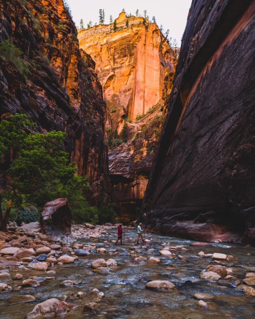 adventure couple hiking the narrows in zion national park