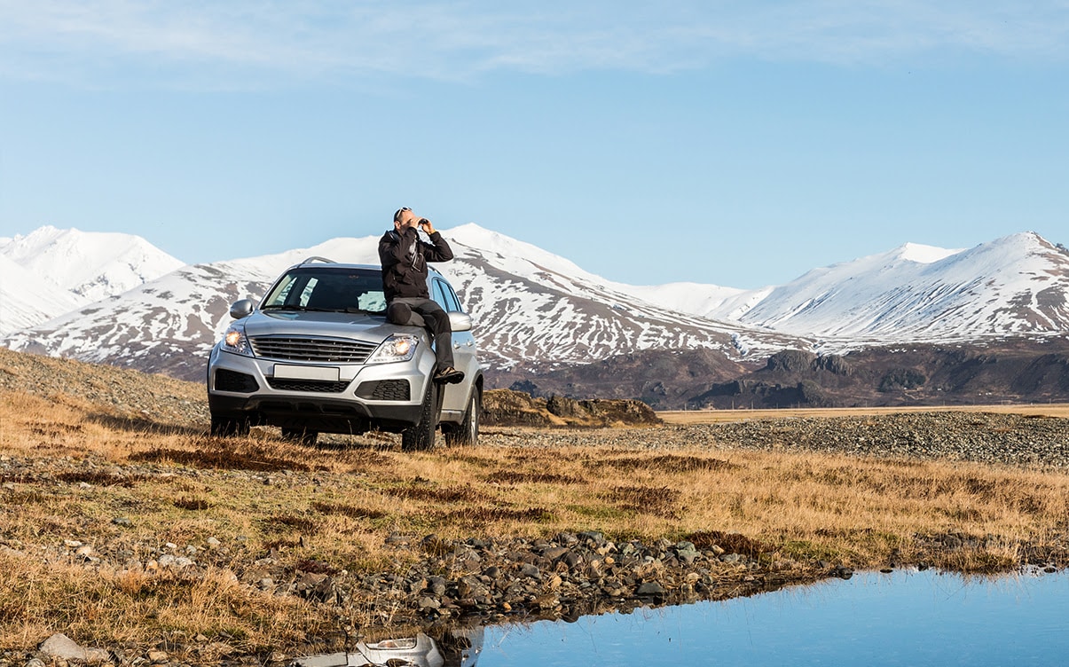 A Man Sitting on a Car in Iceland