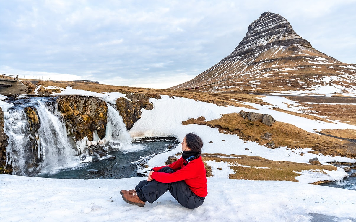 A Woman Visiting the Kirkjufellfoss Waterfall in the Winter