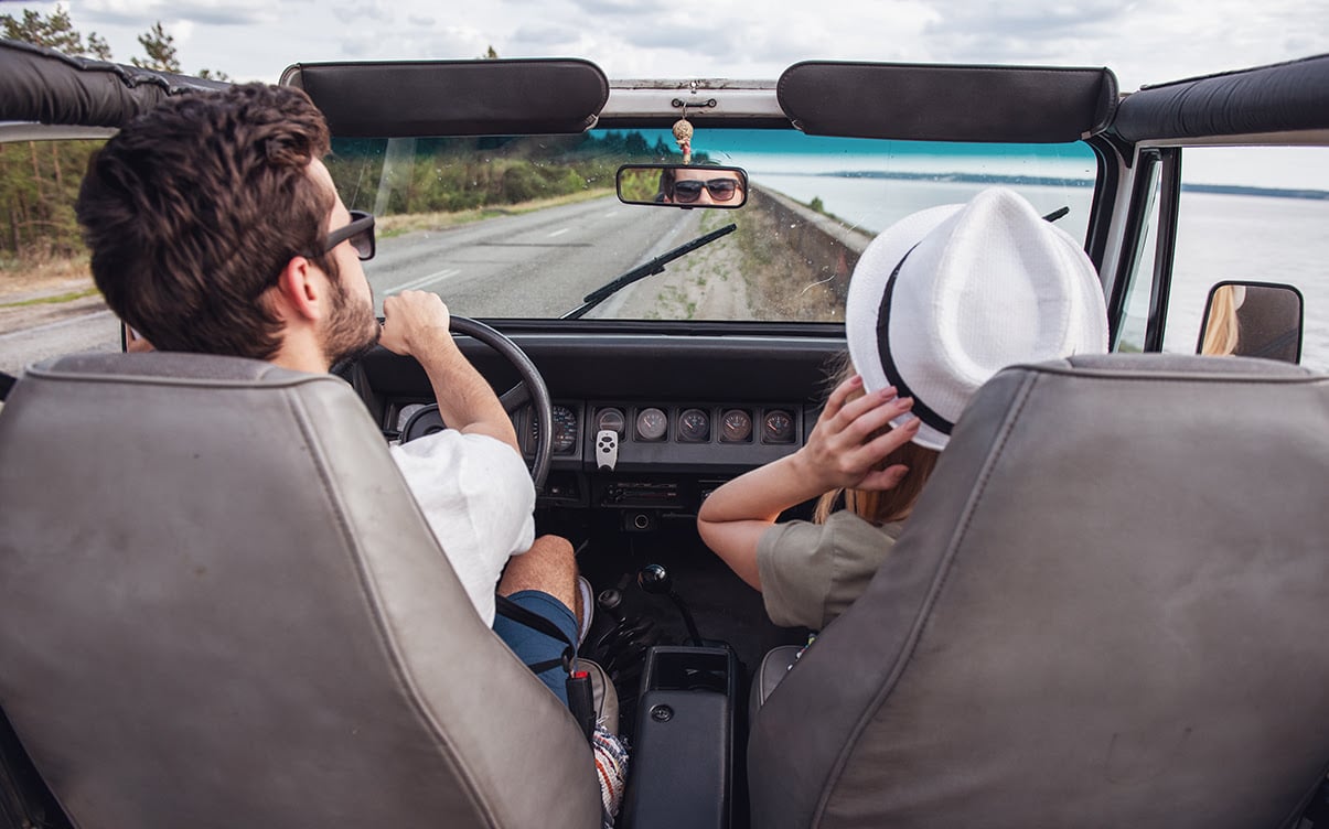 A Couple Driving Alongside the Ocean