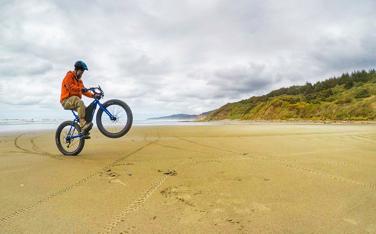 A Man Riding a Bike on a Beach