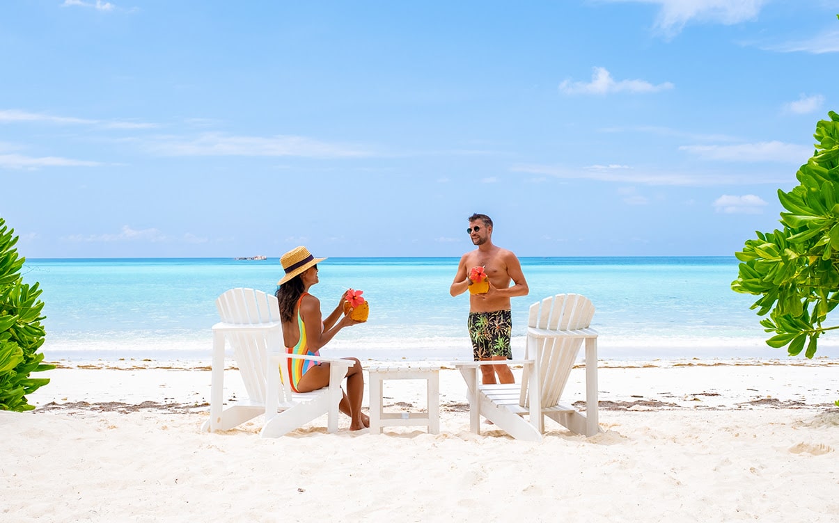 A Couple Enjoying Tropical Drinks on a Beach