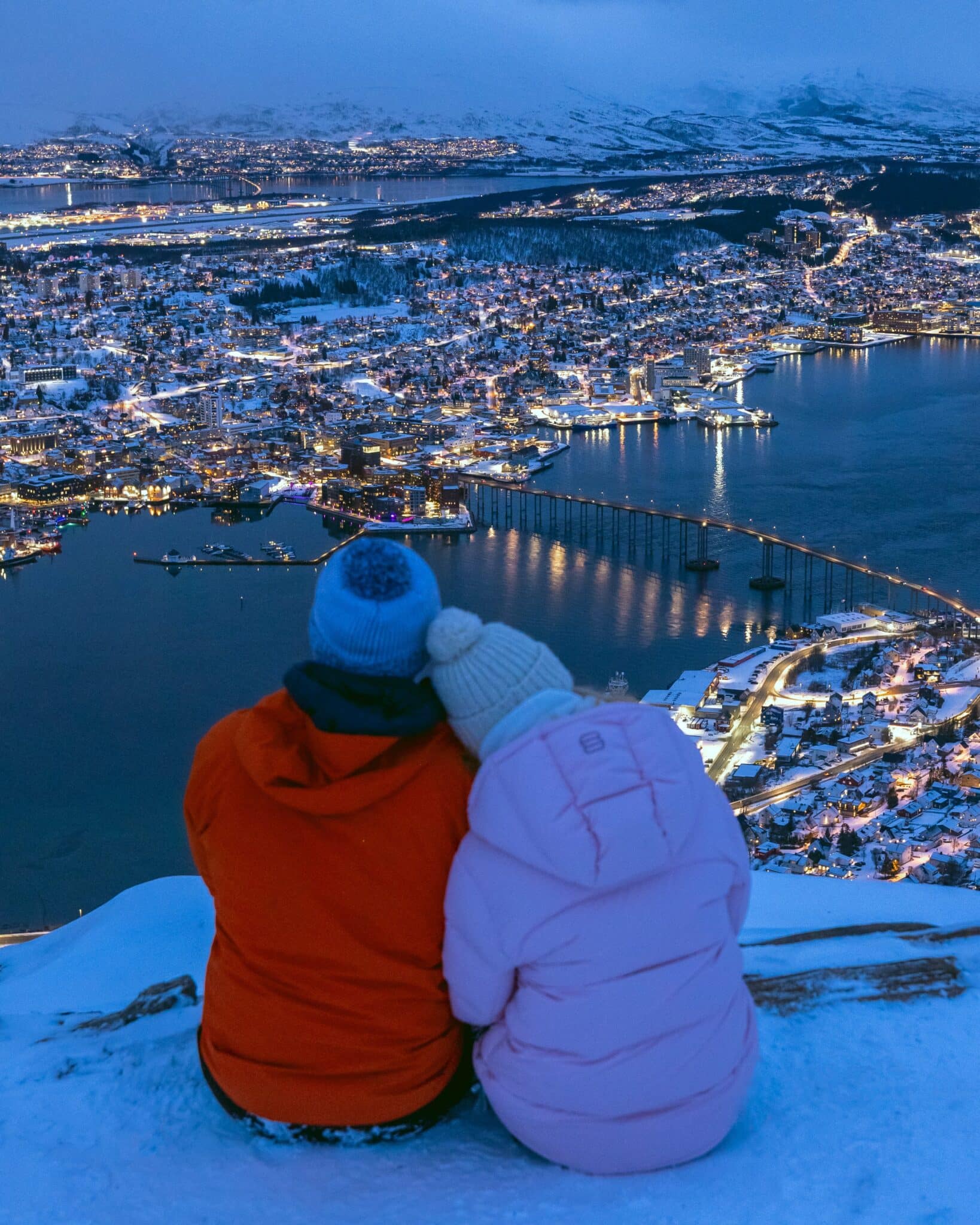 Tromso City Norway Couple sitting above Tromso, Norway at Cable Car Station