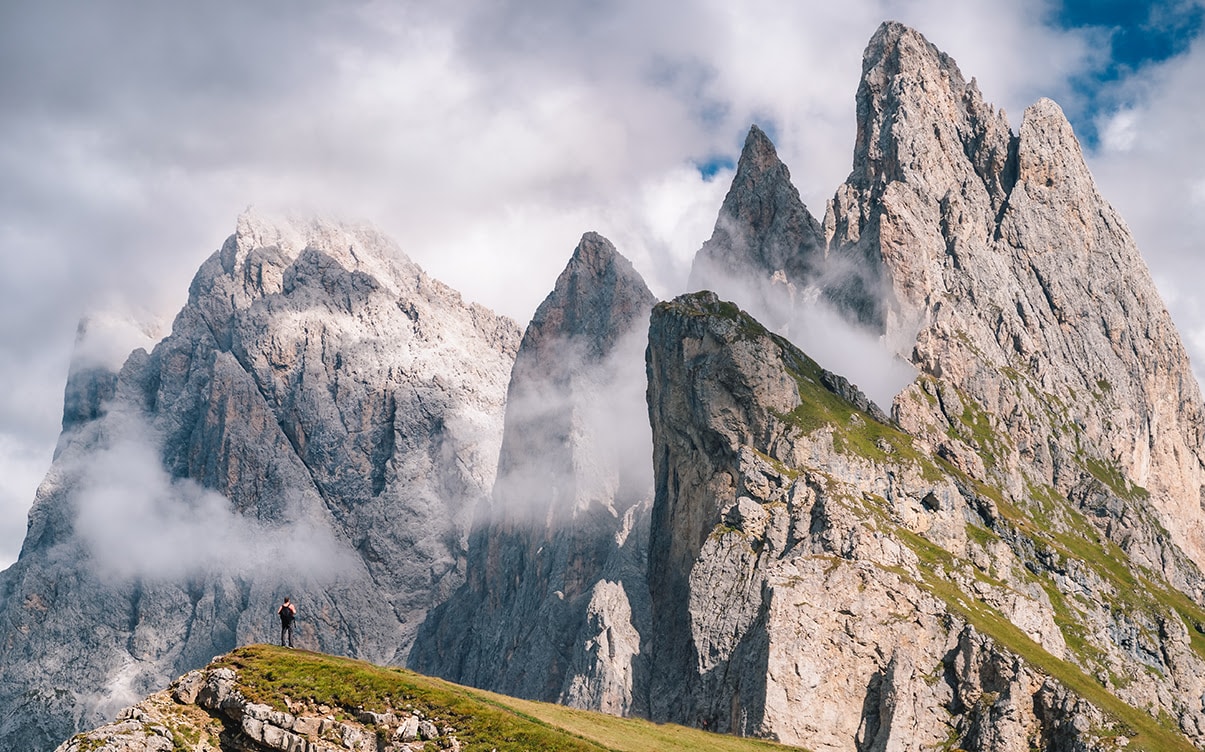 A Hiker Looking at Peaks in the Dolomites