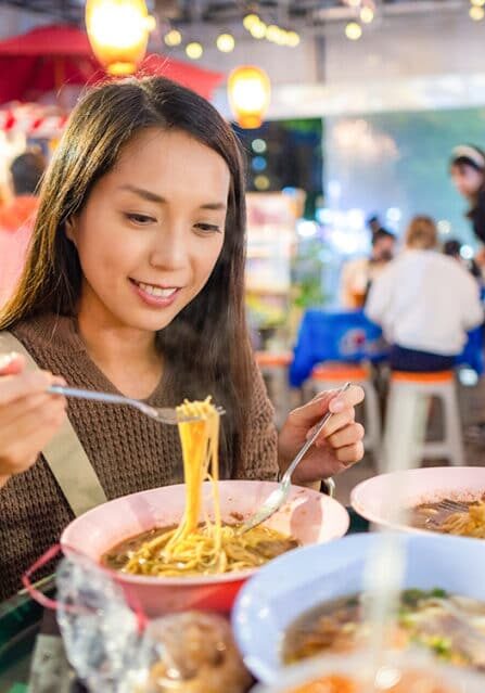 A Woman Eating Street Food