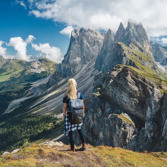 A Woman Standing at a Peak in the Dolomites