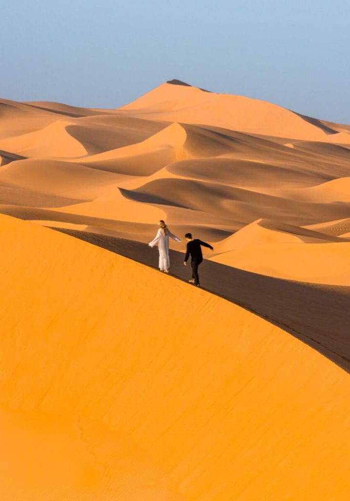 Couple walking on Abu Dhabi Sand Dunes at Telal Resort in Al Ain