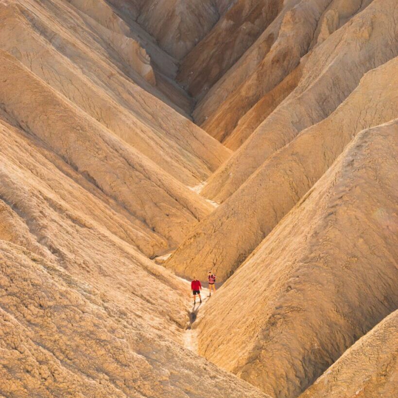 couple hiking through Golden Canyon in Death Valley National Park