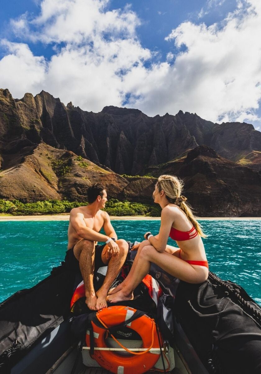 Adventure couple traveling to the napali coast on kauai via boat